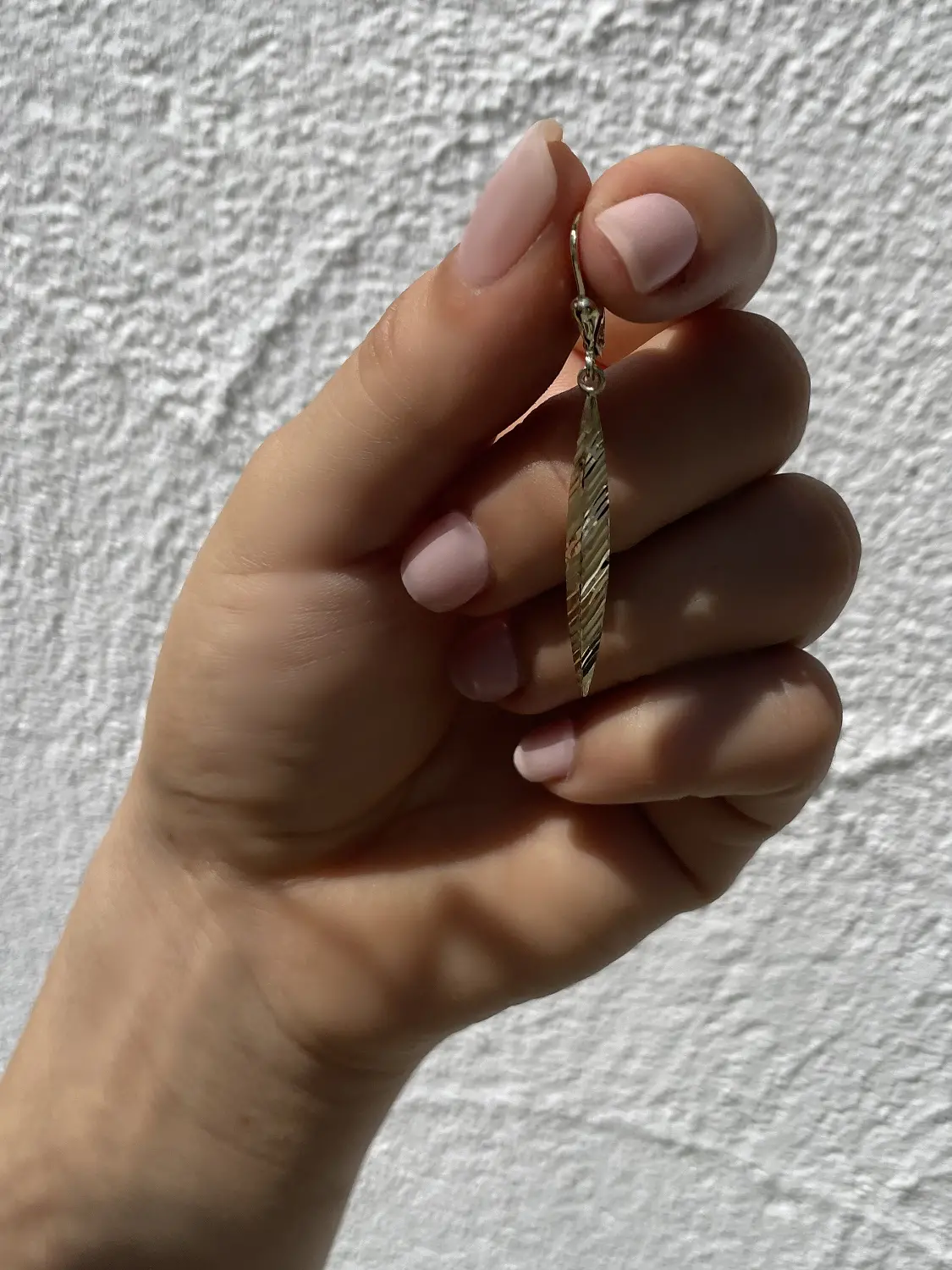 Damenohrringe aus echtem Gelbgold in Damenhand haltend - Annesca | Skintype