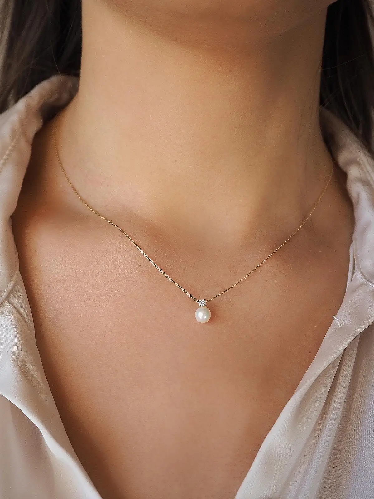 Anhänger aus echtem Gelbgold mit Zirkonia & Süßwasserperle an Damendekollete- Gracia | Skintype