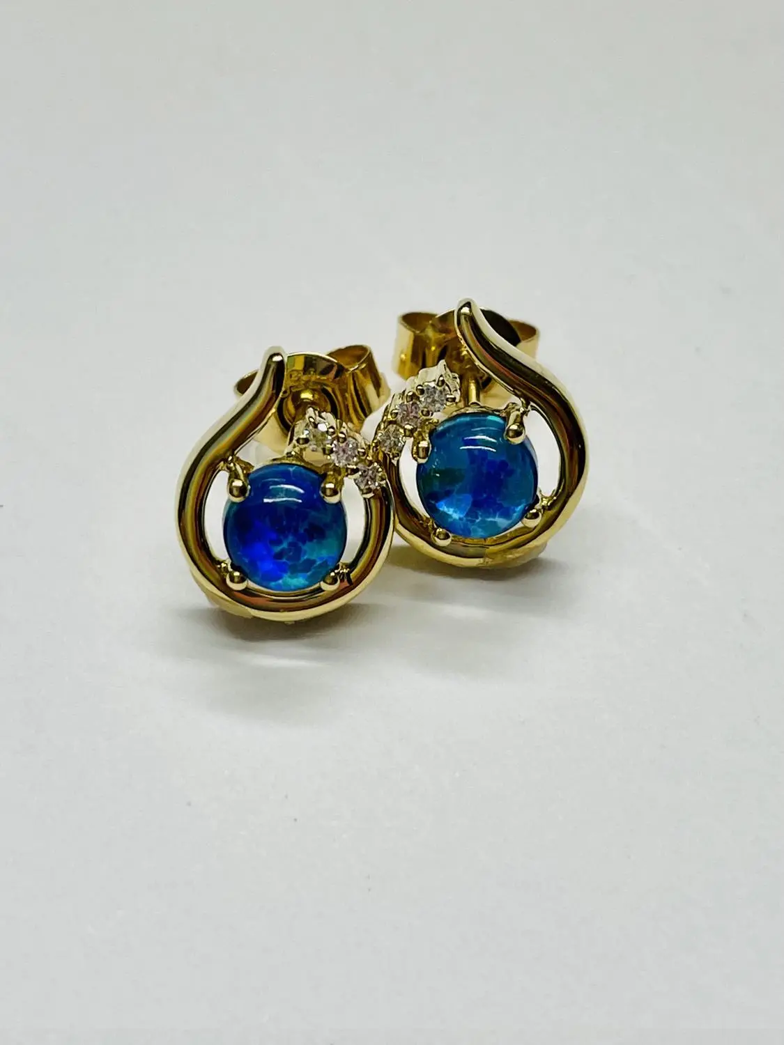 Damenohrringe aus echtem Gelbgold mit Diamant & Opaltriplette auf Unterlage - Sala | Stilleben