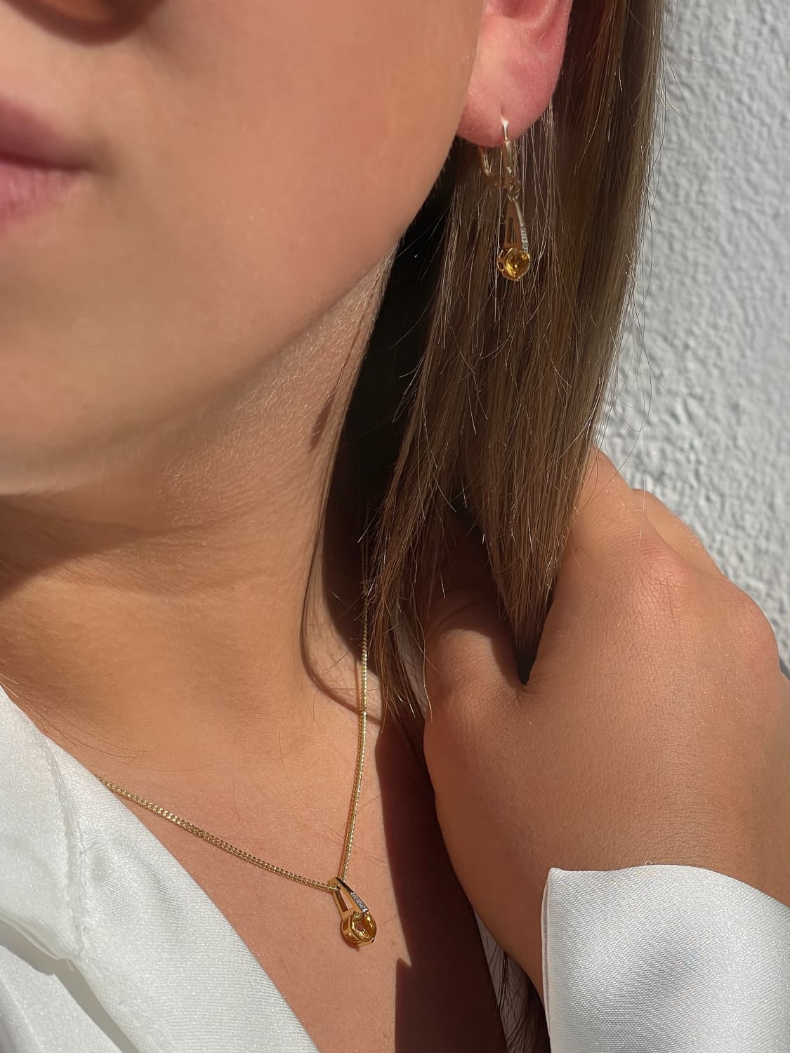 Damenanhänger und Damenohrring aus echtem Gelbgold mit Citrin Edelsteinen am Damenohr und Damendekollete - Kaydence | Skintype