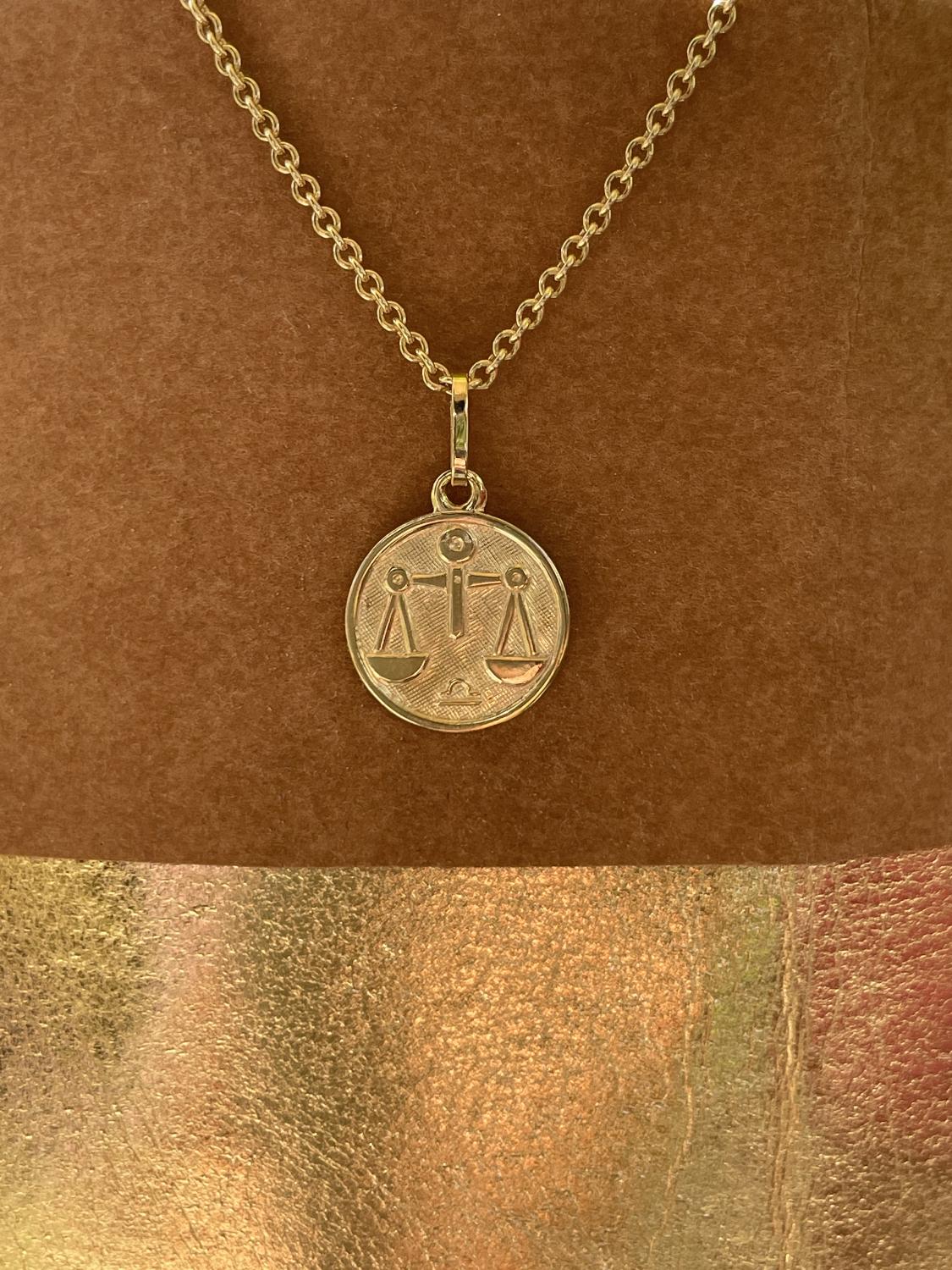 Unisexanhänger aus echtem Gelbgold Sternezeichen Waage an Papiertüte - Zodiac Round | Stilleben