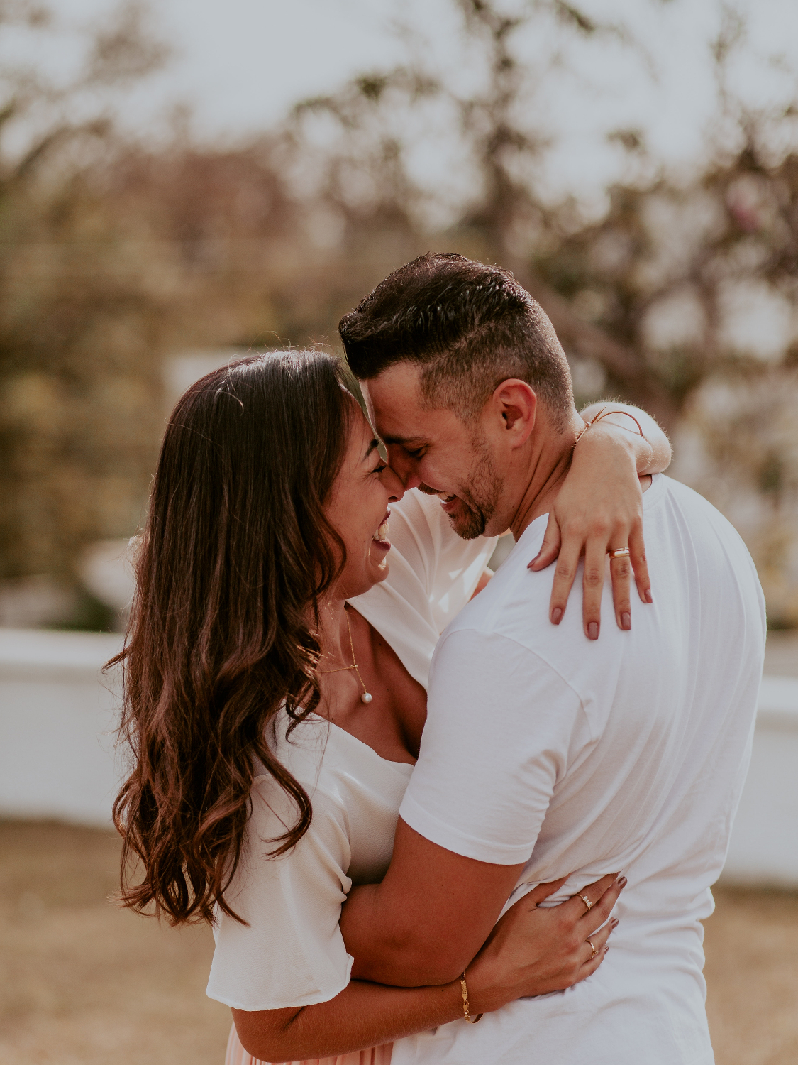 Mann hält seine lachende Frau liebevoll im Arm - Momente des Schenkens | Emotionsbild