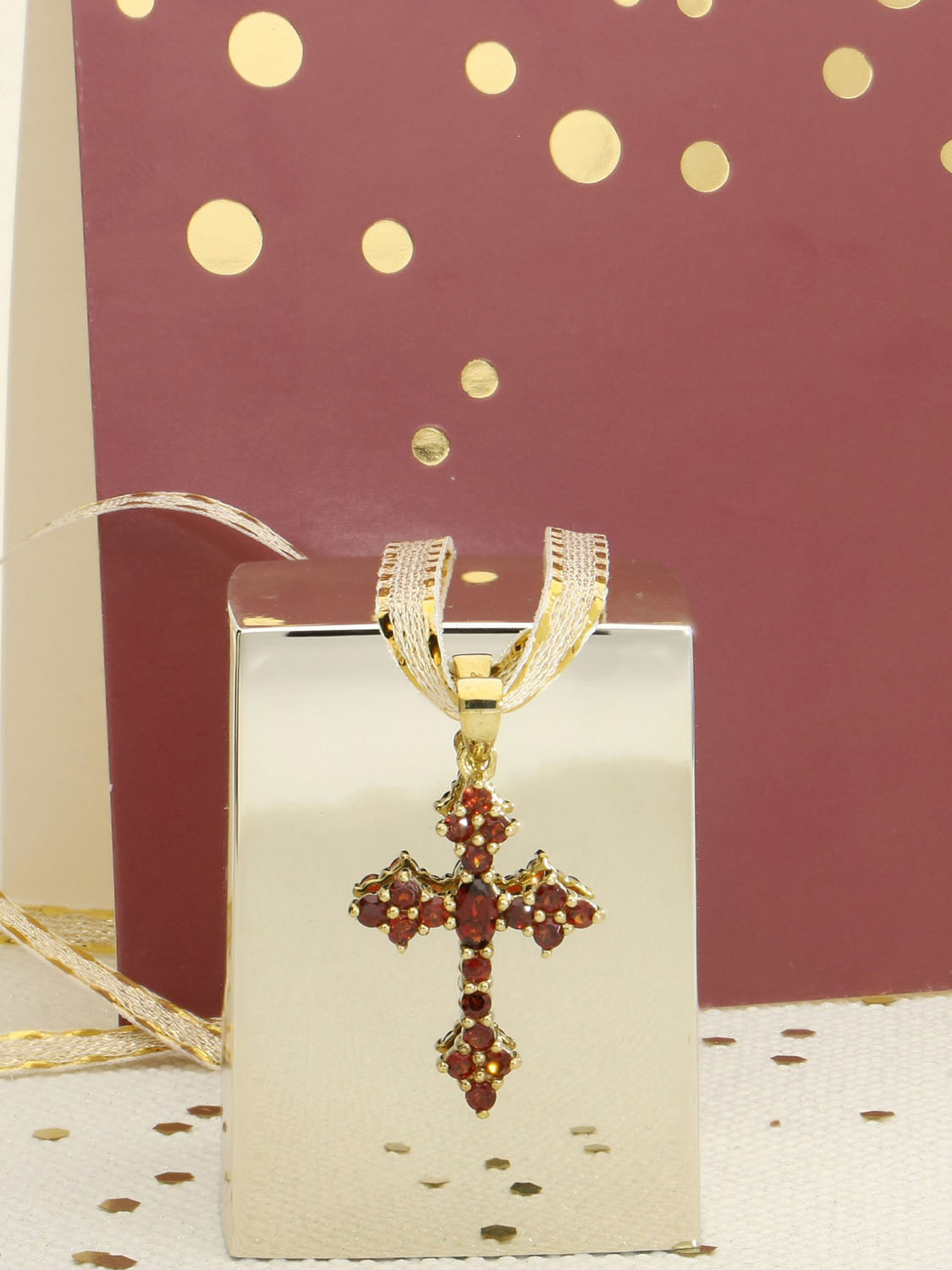 Kreuzanhänger für Damen aus echtem Gelbgold mit Granat Edelsteinen mit Dekoartikeln - Glorian | Stilleben